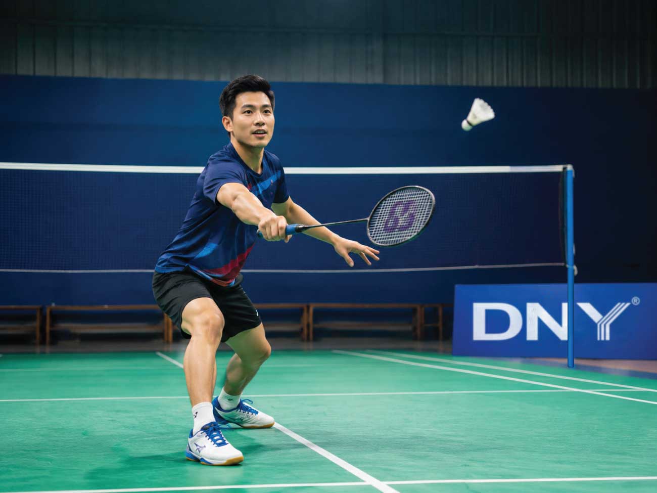Người chơi cầu lông trên sân trong nhà chuẩn bị thực hiện cú đánh